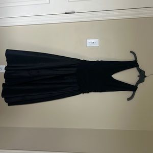 A black midi dress with ruffle detail in the middle and  cropped jacket